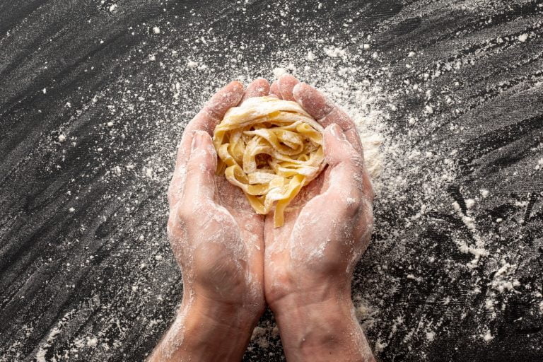 hands holding uncooked tagliatelle